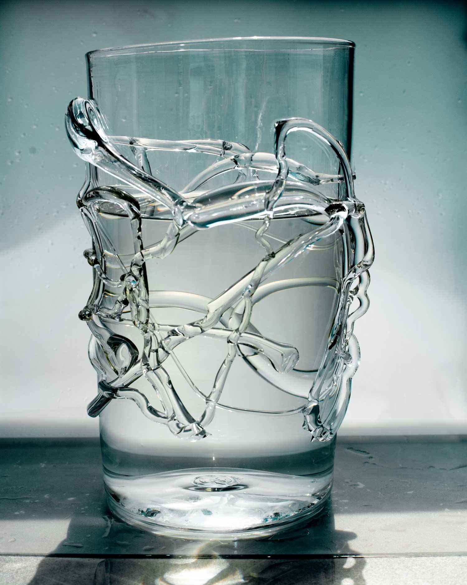 Large vase with details of glass melted with water white background and shadow
