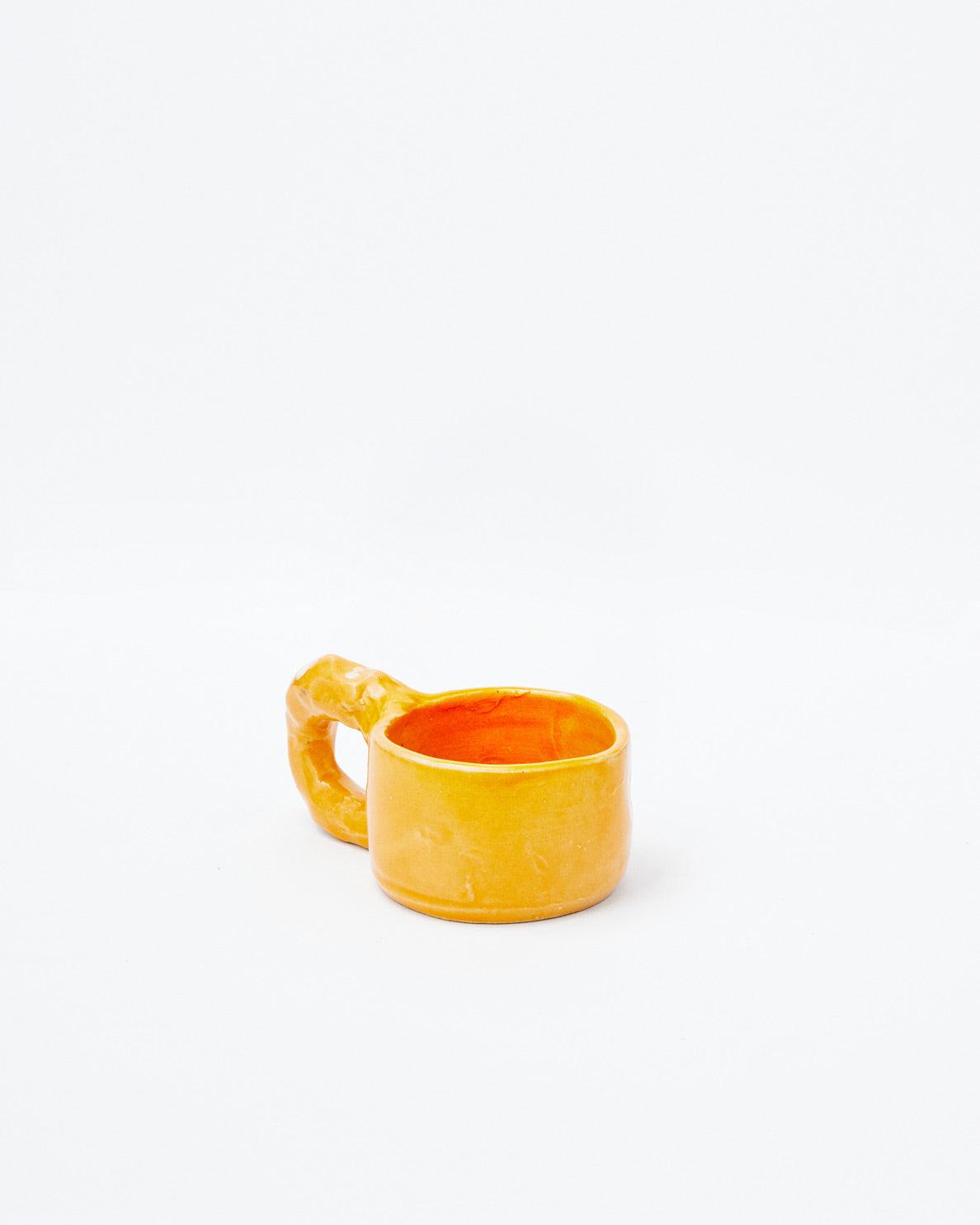 White background, orange modern ceramic cup with slanting handle