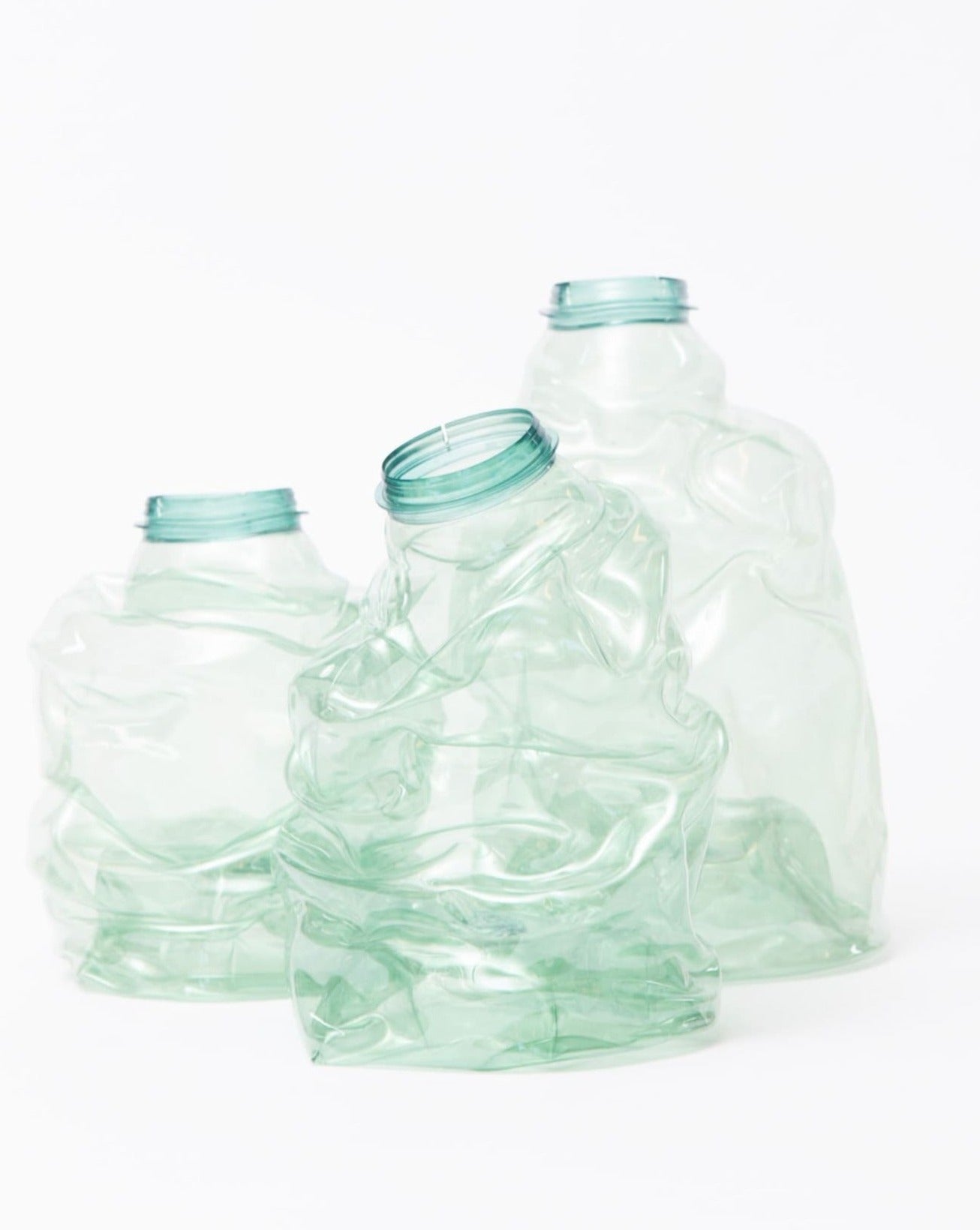 Green recycled plastic vases placed simultaneously on a white background