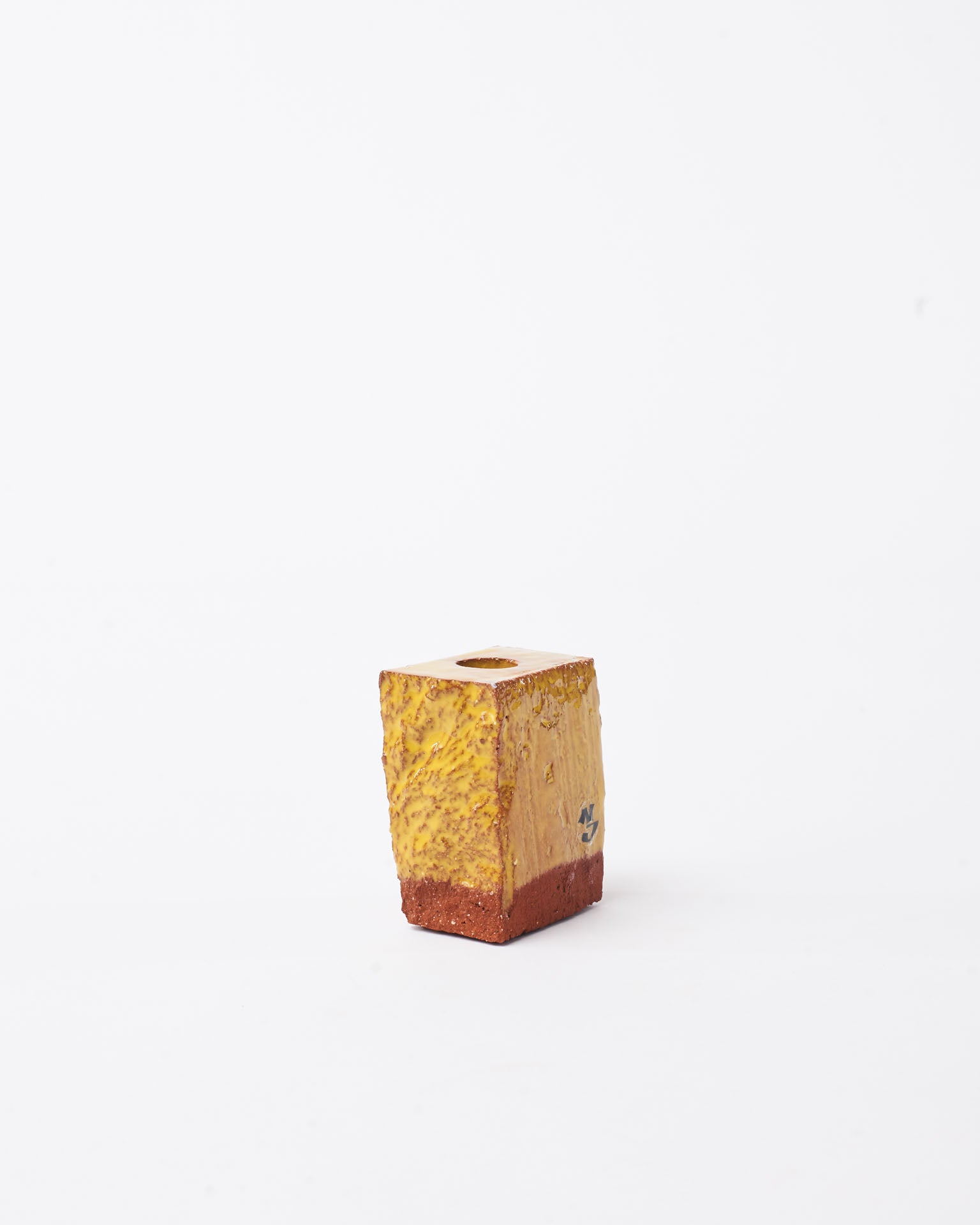 Handmade yellow brick ceramic candle holder small in white background