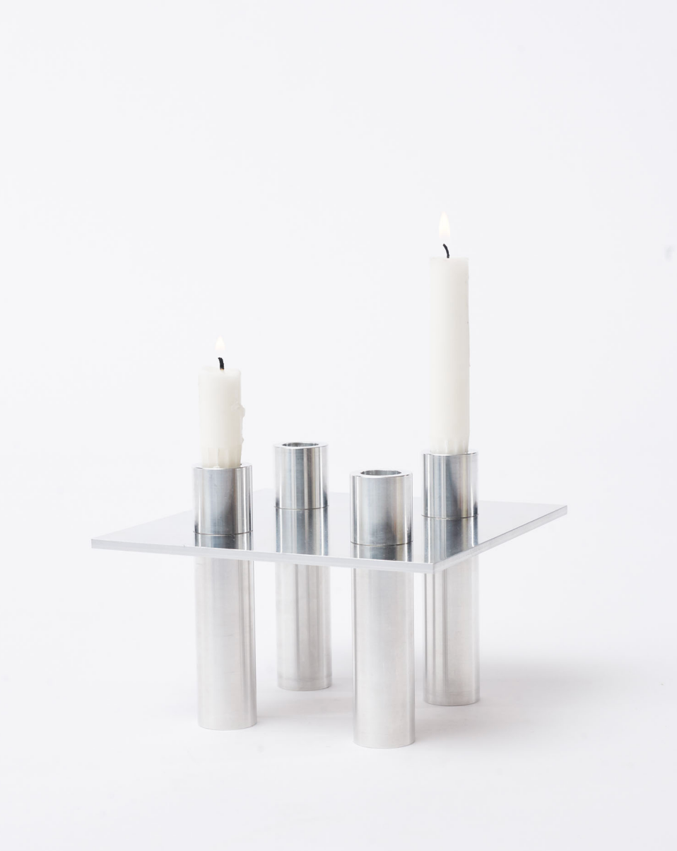 Two lighted candles on an aluminum candlestick P-L series with white background