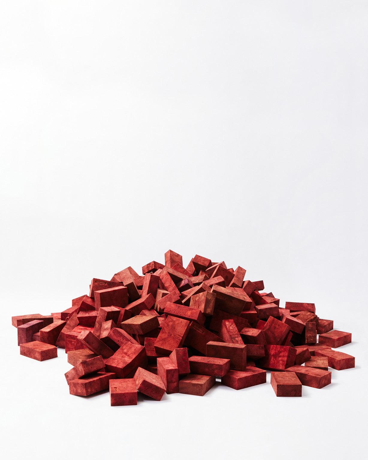 Red bricks mounted on top of each other in the shape of a mountain on a white background