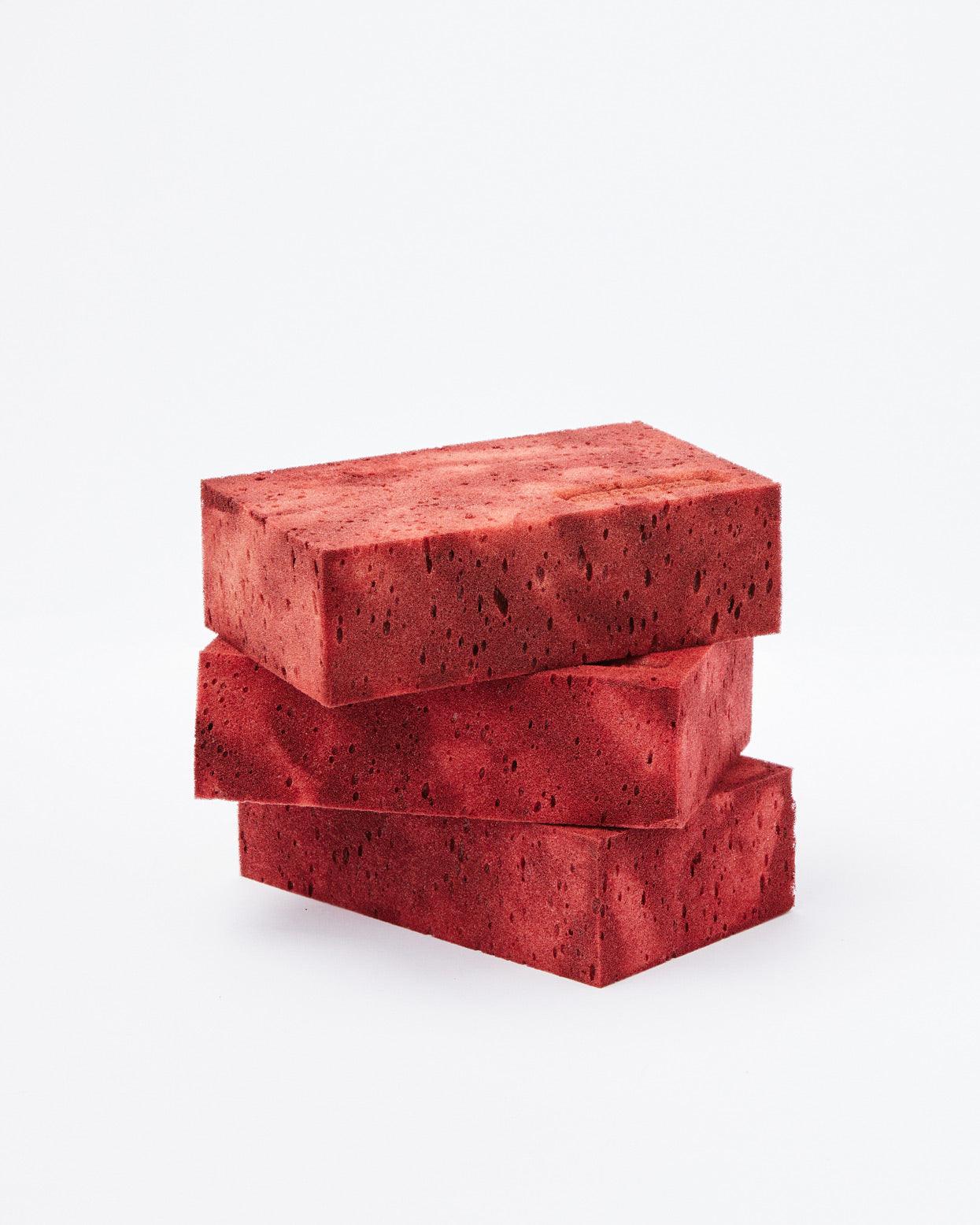 Three red bricks in vertical position on a white background
