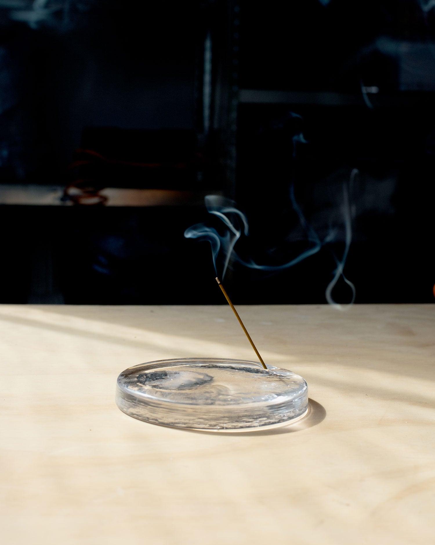 Handmade glass incense burner standing horizontally on white background