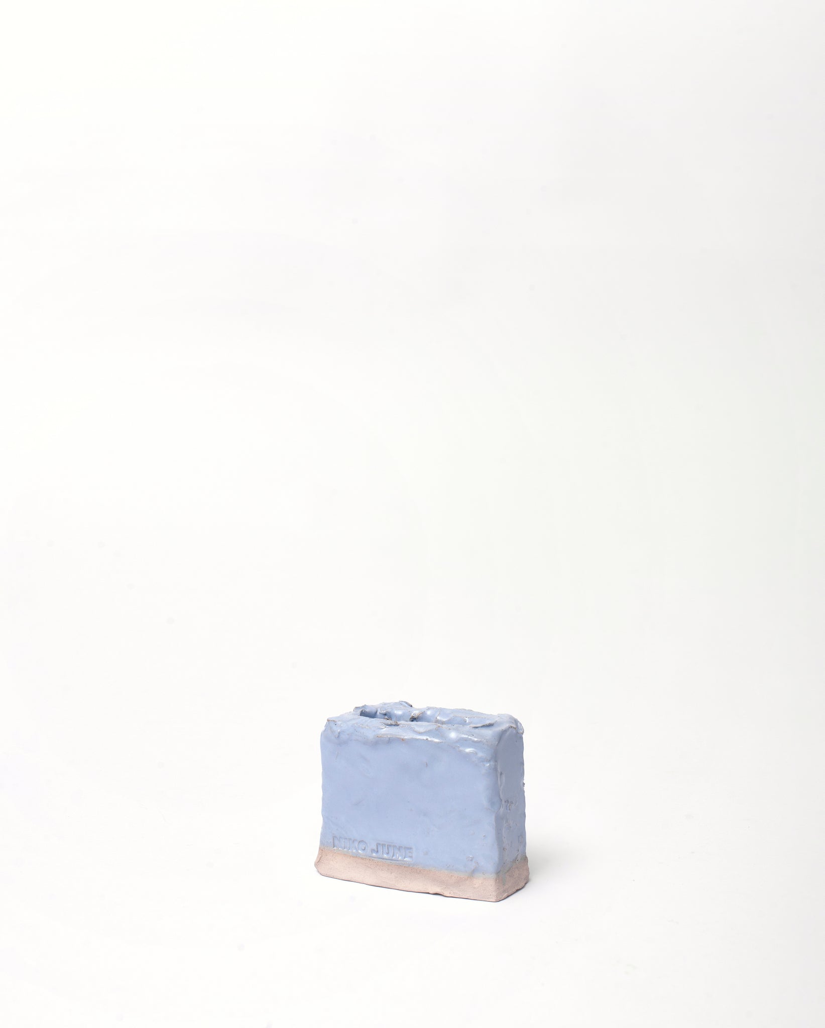 Handmade ceramic organizer object in light blue glaze inclination vertical in white background 