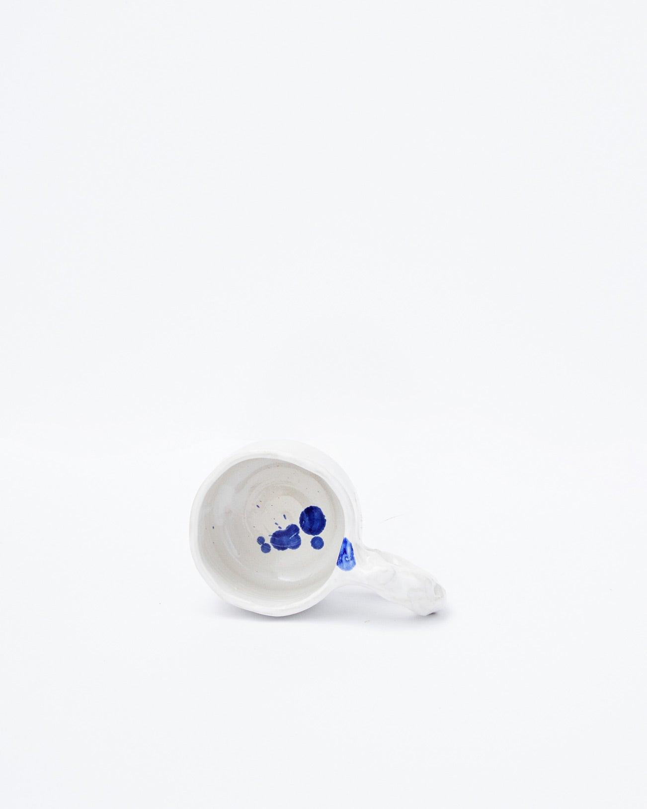 White background, white modern ceramic cup with lying handle
