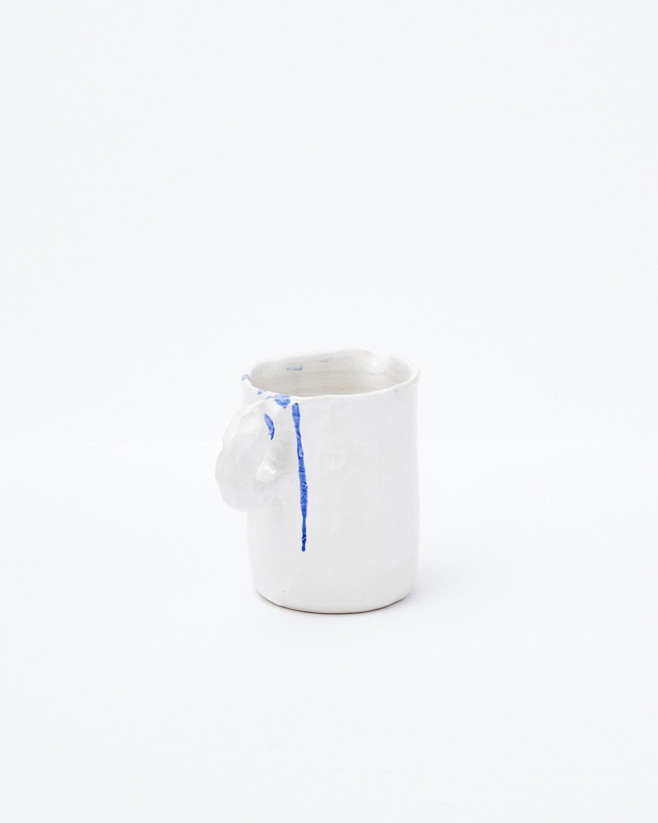 White modern ceramic pitcher with diagonal handle on a white background
