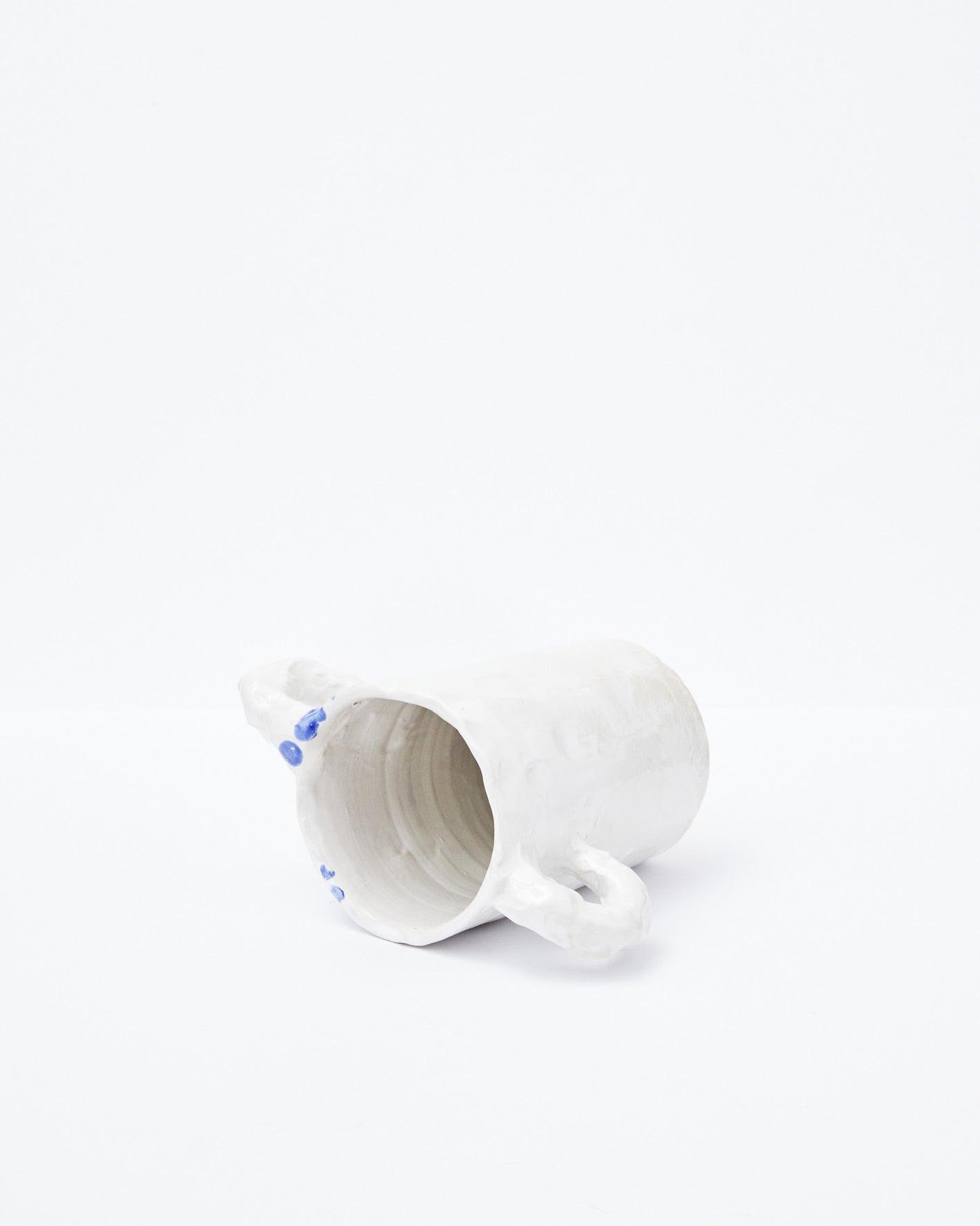 White modern ceramic vase with two handles diagonally positioned on a white background