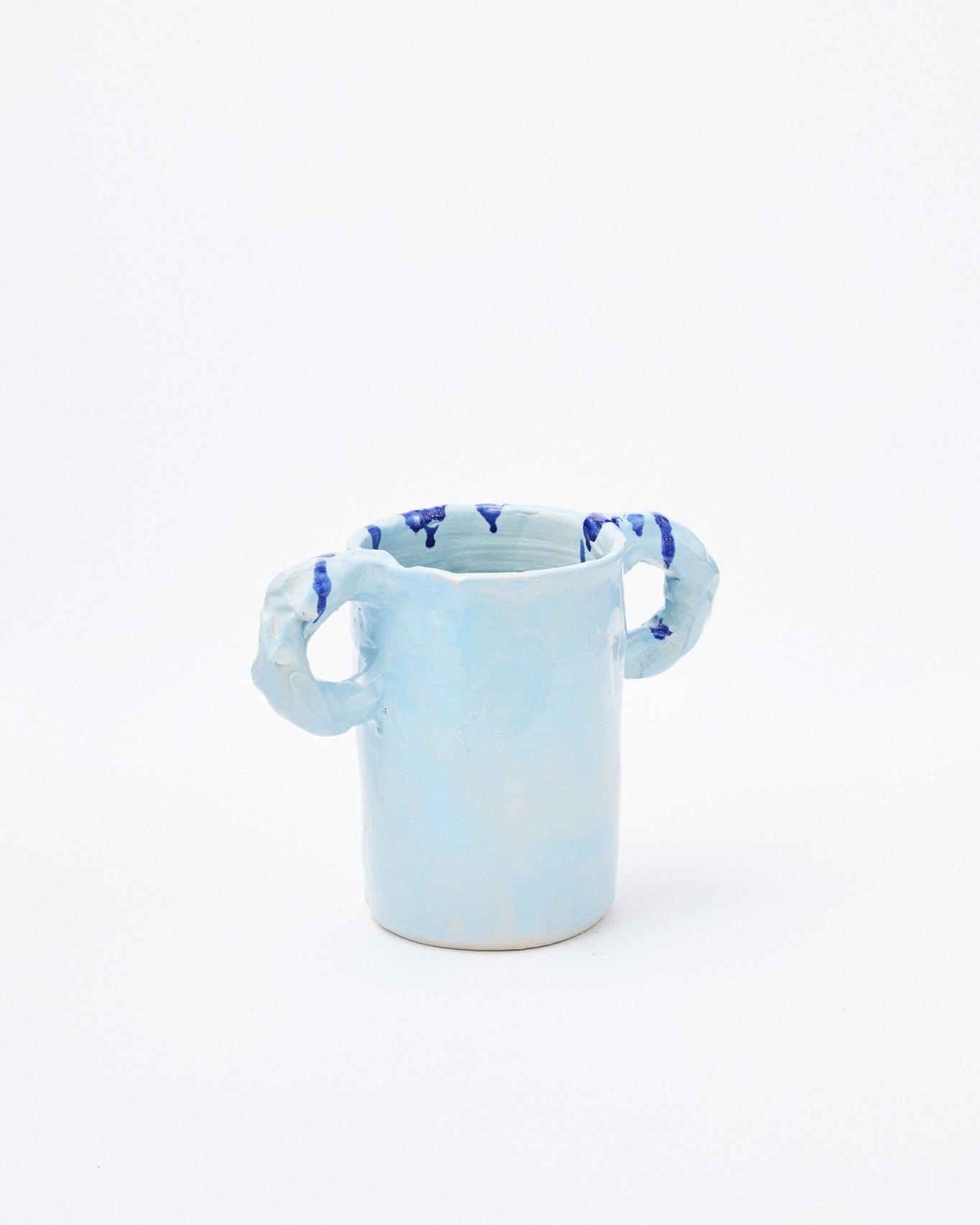 Light blue modern ceramic vase with two handles diagonally positioned on a white background