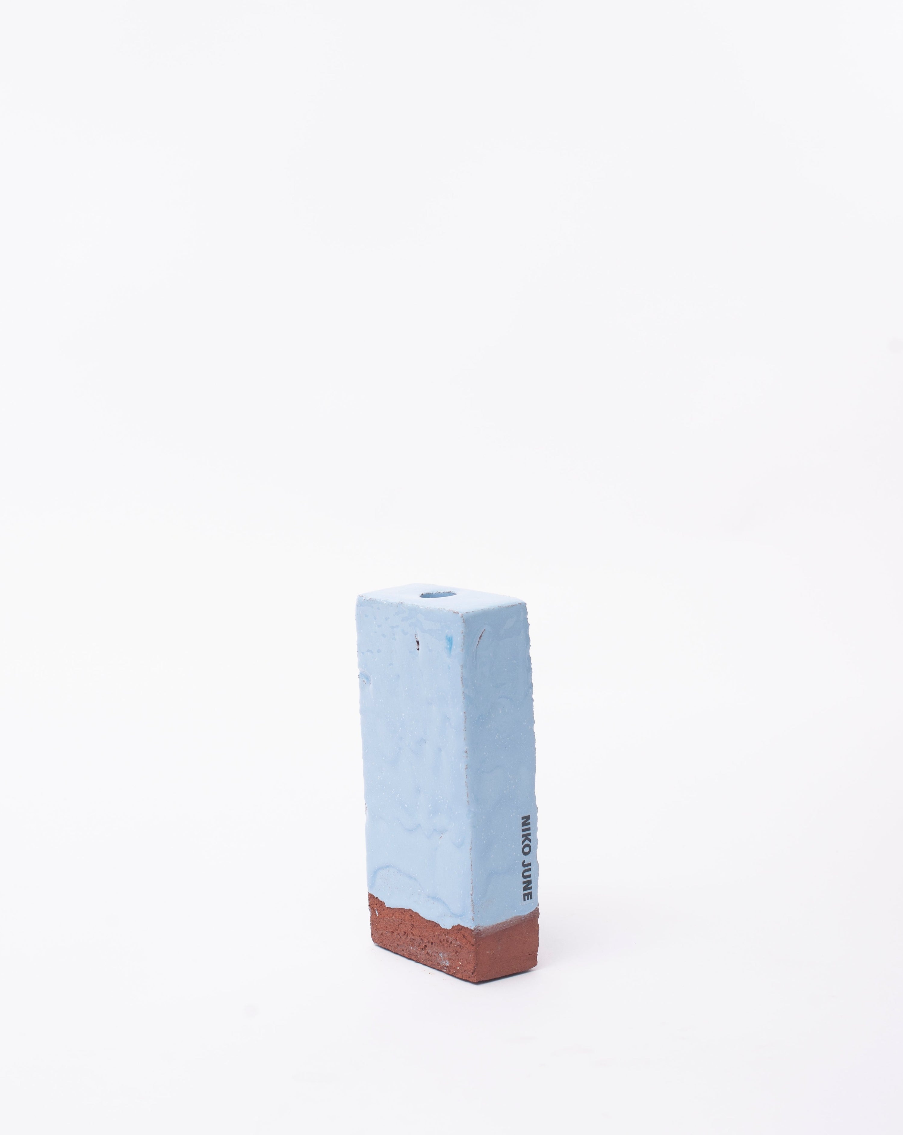 Handmade light blue brick ceramic candle holder in white background with right side view