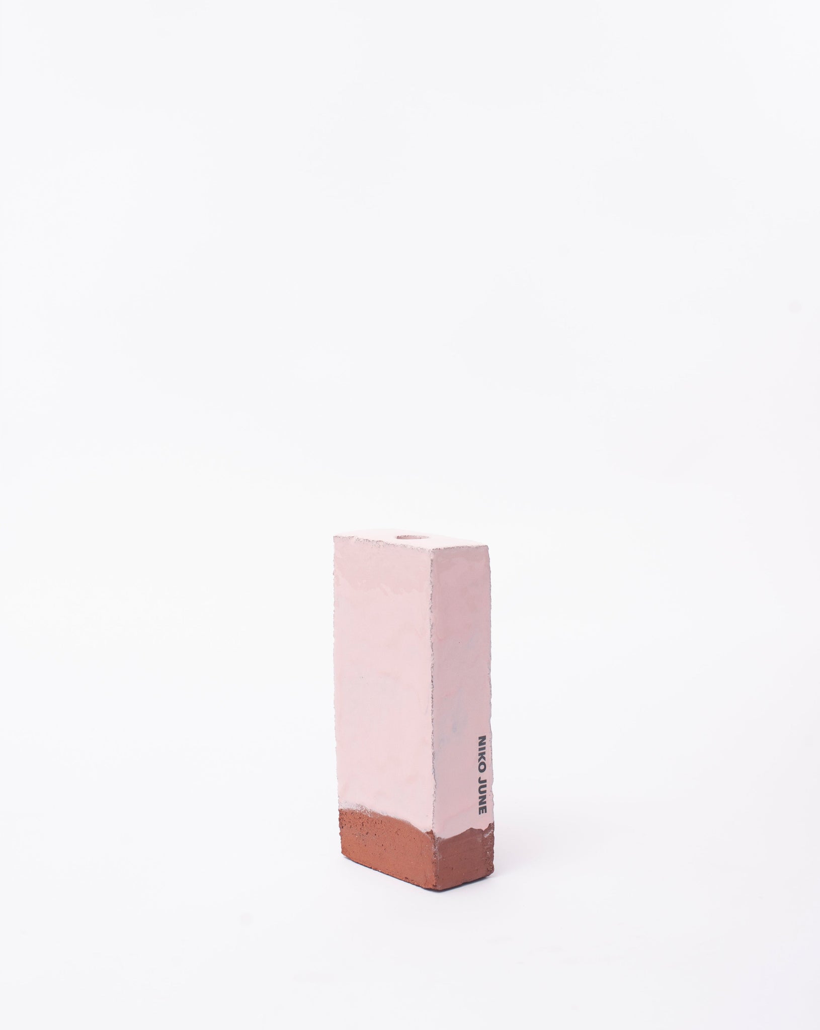 Handmade pink brick ceramic candle holder in white glaze in white background with right side view